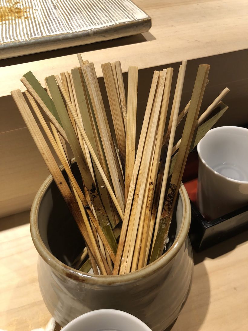 A cup with a bunch of empty skewers.